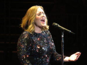 Adele singing on tour in 2016.