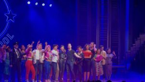 Cast of Grease the musical on stage singing 'Summer nights'