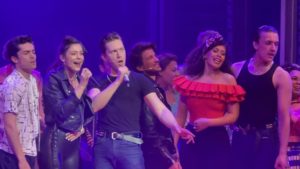 Cast of Grease the musical onstage for the megamix finale